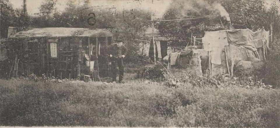 Een tweede ansicht, uitgegeven door de weduwe J.E. Schuuring in Assen, 1900 of 1901: Hans bij de ingang, rechts het bouwsel van takken en doeken met de rokende schoorsteen.