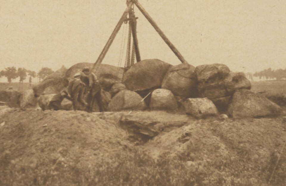 Het onderzoek van september 1927: boven de stenen staat een houten bok met een lier om een deksteen op te takelen. Het werk stond onder leiding van Van Giffen; wie er op de foto staan is niet bekend. Rasterfoto uit het weekblad Het Noorden in Woord en Beeld.