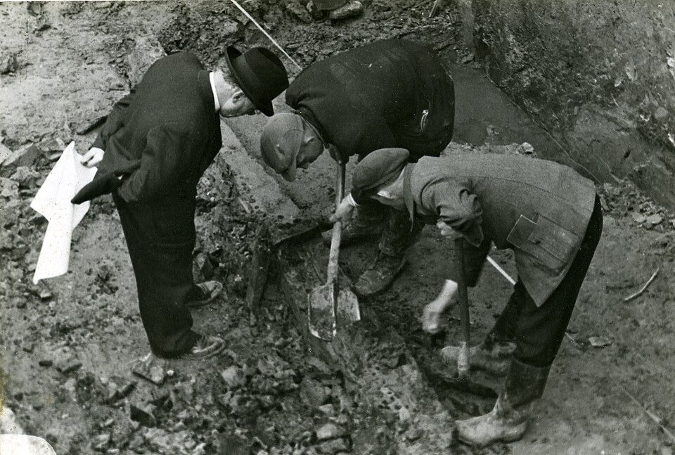 Van Giffen met twee grondwerkers bij de opgraving van het Romeinse castellum in Valkenburg, tussen 1941 en 1943. Hij is de man links, met hoed en de tekeningen in de hand. Buiten dit kaartvlak, maar het is de enige goede opname waarop hij zelf in het veld staat.