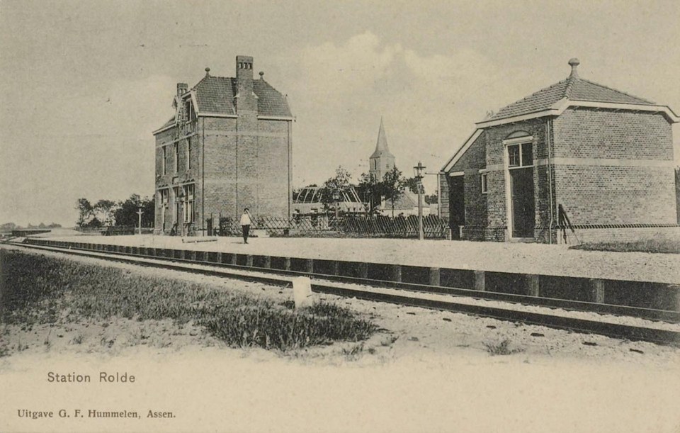 Dezelfde plek in 1908, van verder weg: links het stationsgebouw, rechts het goederenhuis, en daartussen door de toren van de Jacobuskerk. Uitgave G.F. Hummelen, Assen.